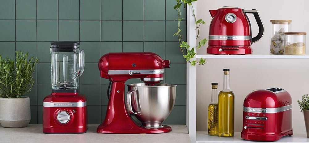 Czerwony komplet urządzeń KitchenAid: blender kielichowy, robot kuchenny, czajnik i toster w kuchennej aranżacji